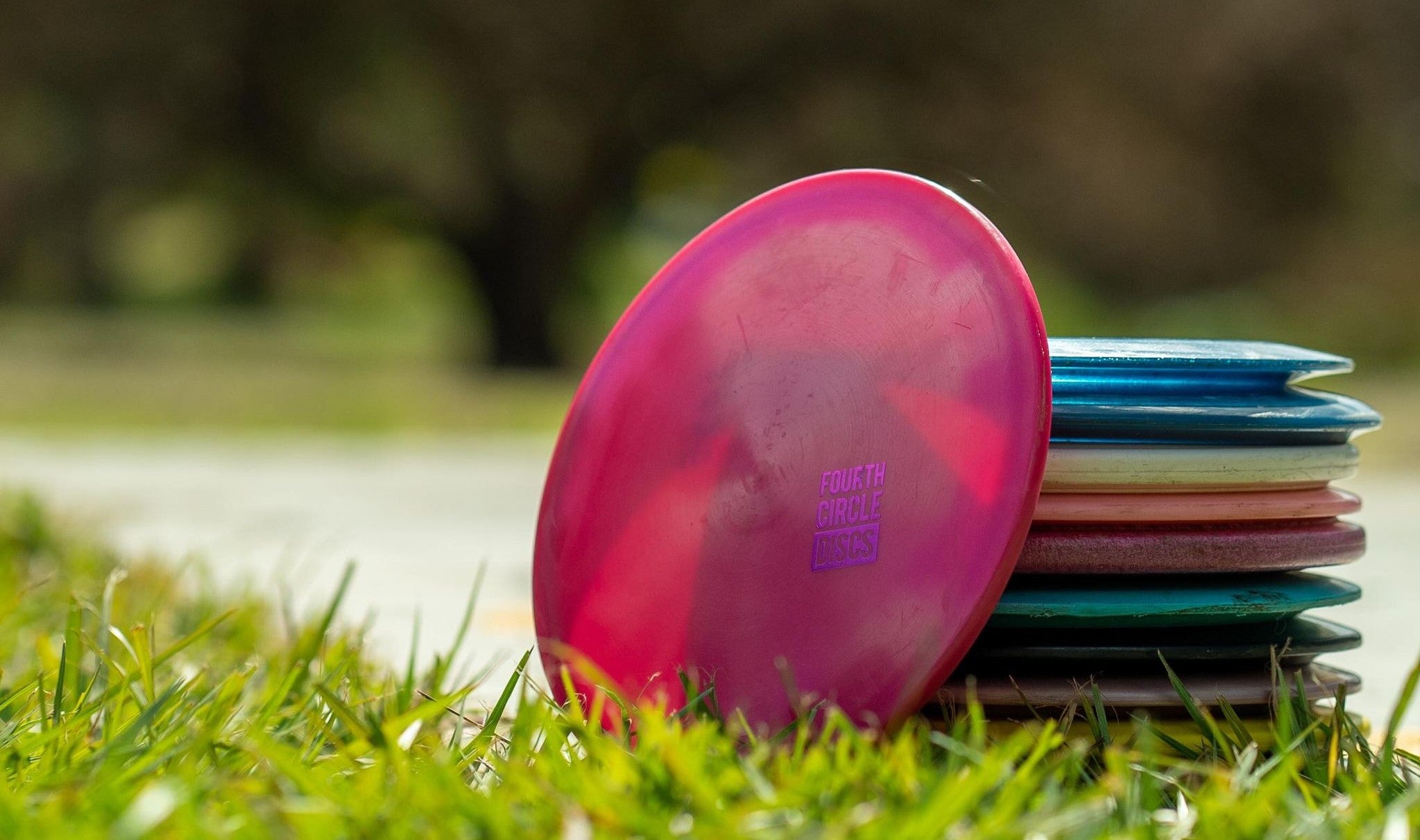 A stack of beginner disc golf discs on the grass