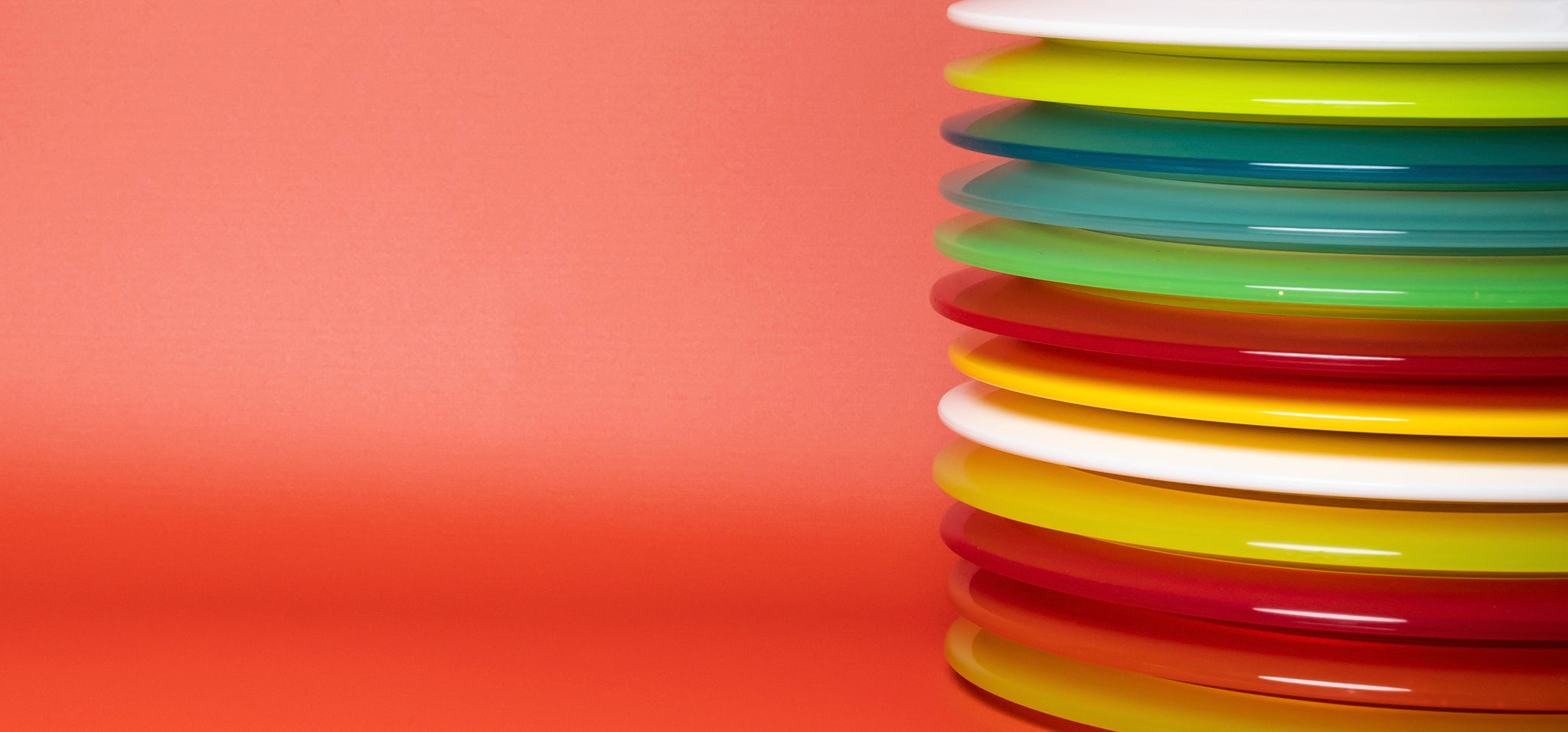 A stack of Disc Golf Distance Drivers on Red Background
