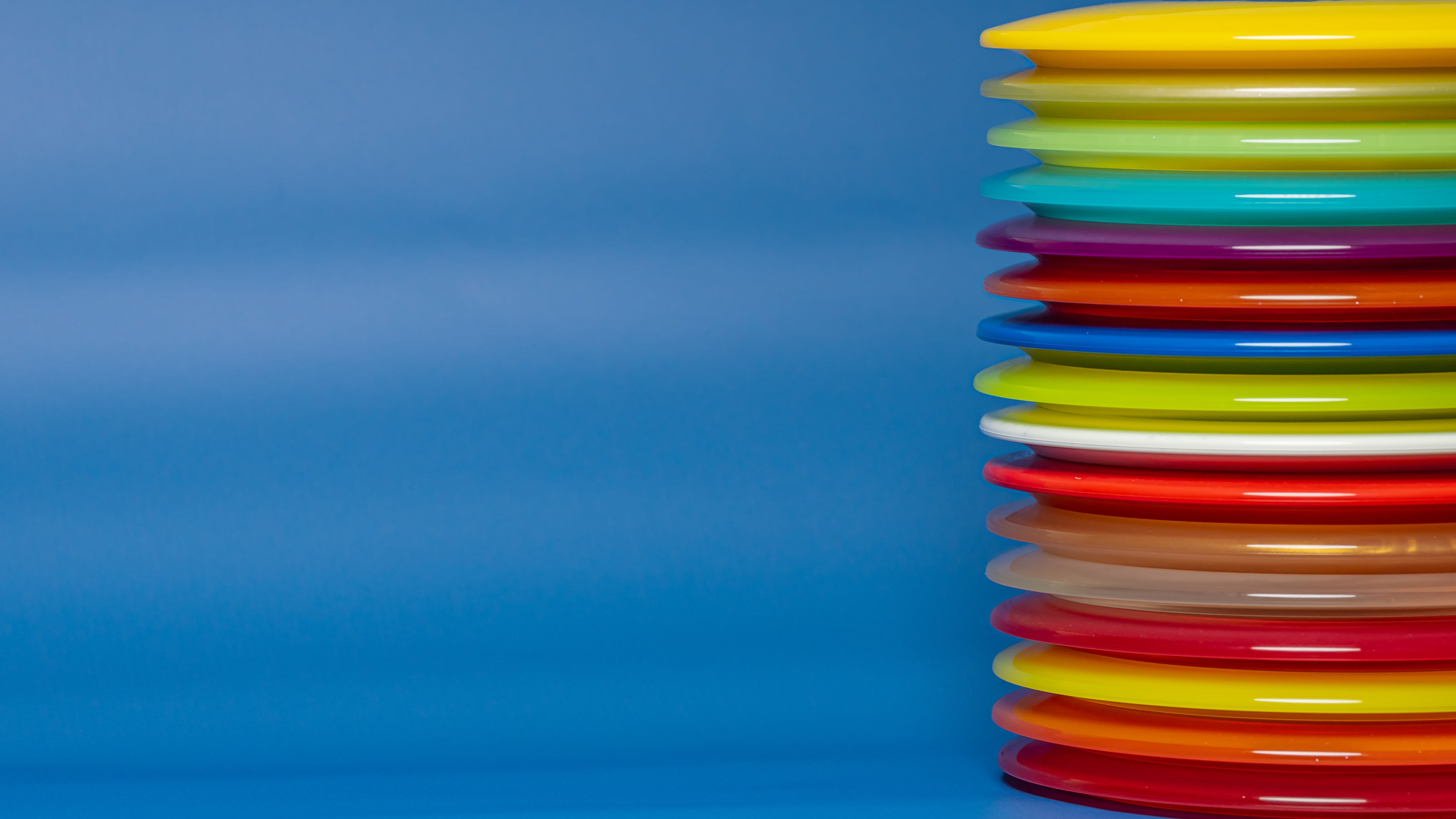 Stack of disc golf discs on a blue background