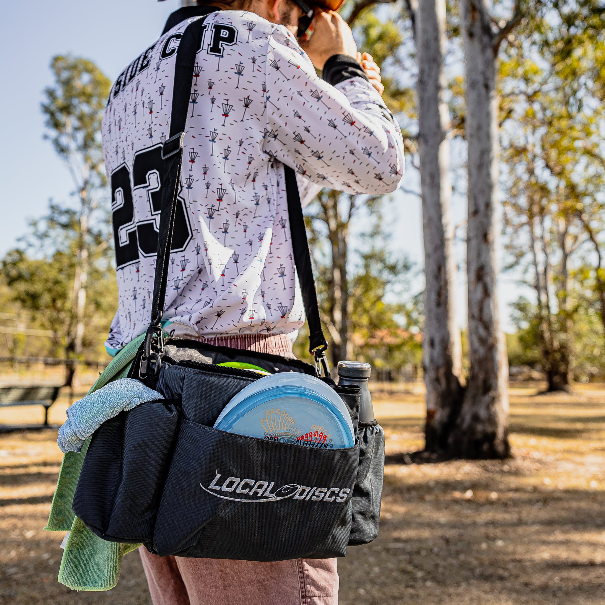 Local Discs disc golf bag with discs on a player's shoulder